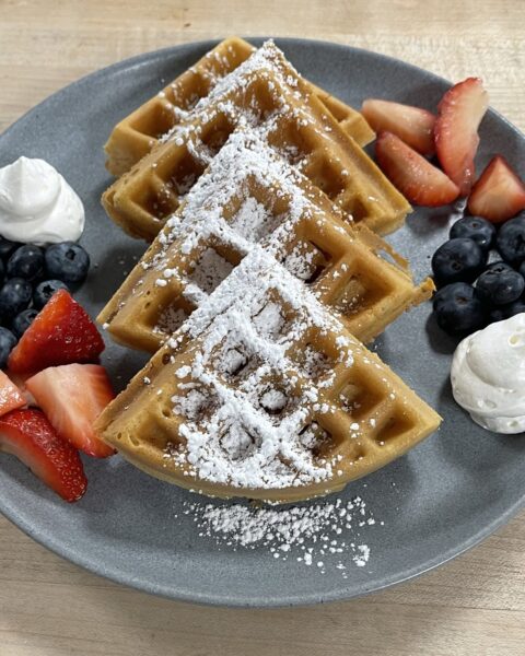waffles with fruit and cream on a plate